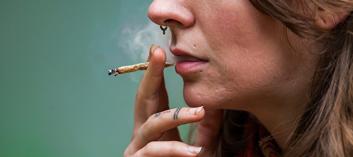 Eine junge Frau raucht einen Joint