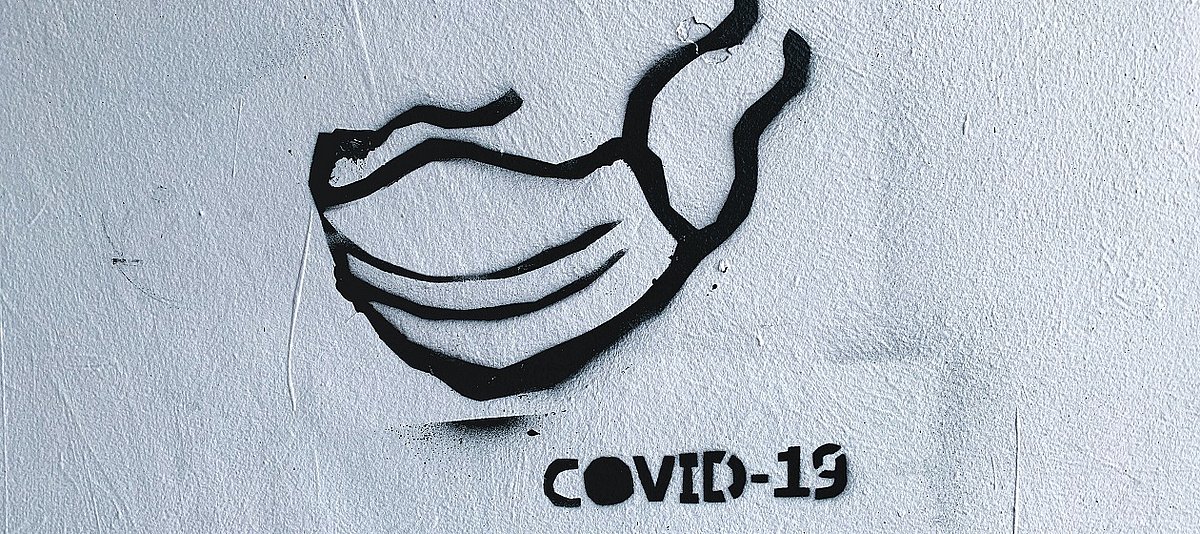 Graffiti einer Atemschutzmaske mit Covid-19 Signatur
