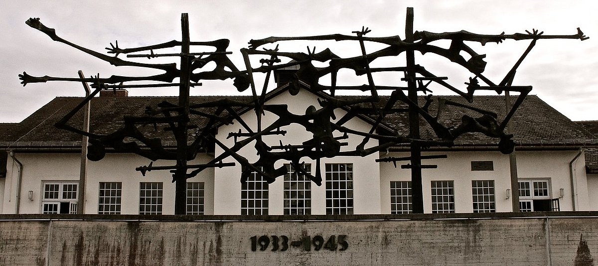 Im Monument „Skelette im Stacheldraht“ im KZ Dachau sind menschliche Skelette mit Stacheldraht verwachsen.