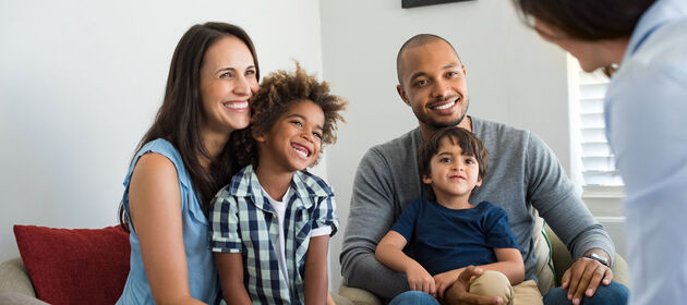 Ein Therapeut spricht mit einer Familie, bei der die Eltern unterschiedlicher Herkunft sind.