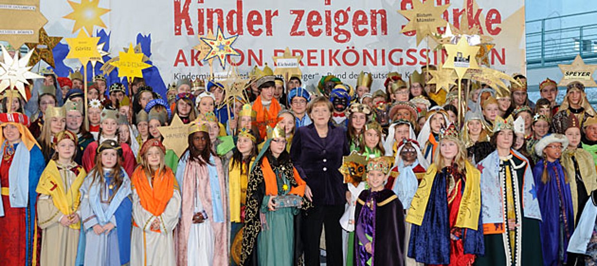Bundeskanzlerin Angela Merkel mit Sternsingern
