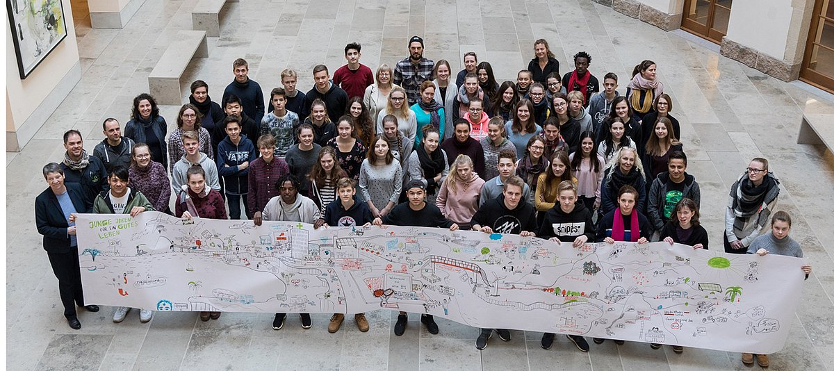 Die Teilnehmenden der Jugendkonferenz mit der "Landkarte des guten Lebens und Bundesumweltministerin Hendricks im Foyer des Bundesumweltministeriums. 
