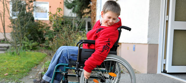 Ein lachender Junge im Rollstuhl