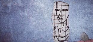 Streetart-Bild einer Person hinter Gitter auf einer Mauer