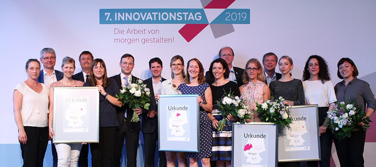 Die Preisträger „Innovatives Netzwerk 2019“ bei der Auszeichnung im Rahmen des 7. Innovationstages mit Urkunden und Blumen  