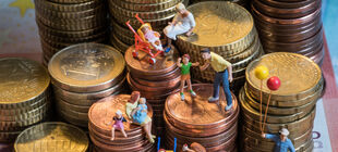 Kleinfamilien auf gestapelten Euromünzen