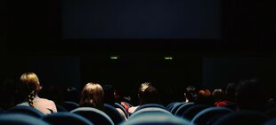 Blick von hinten auf junge Menschen in einem Kino