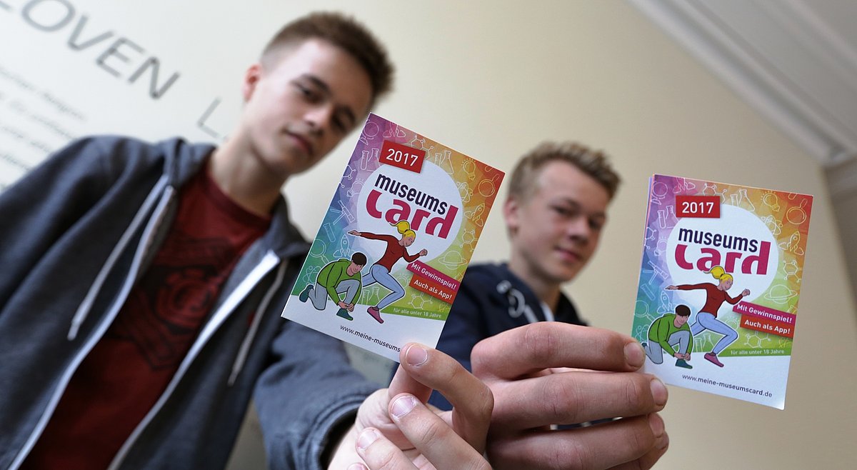 Zwei Jungen zeigen ihre MuseumsCard.
