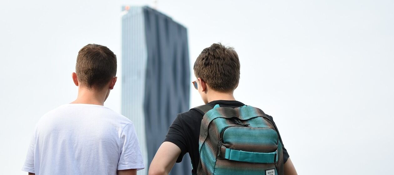 Zwei Jungen stehen vor dem DC Tower 1 in Wien.