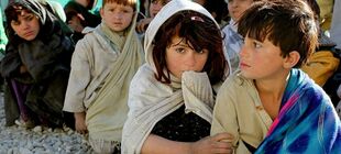 Gruppe afghanische Kinder die auf dem Boden sitzen