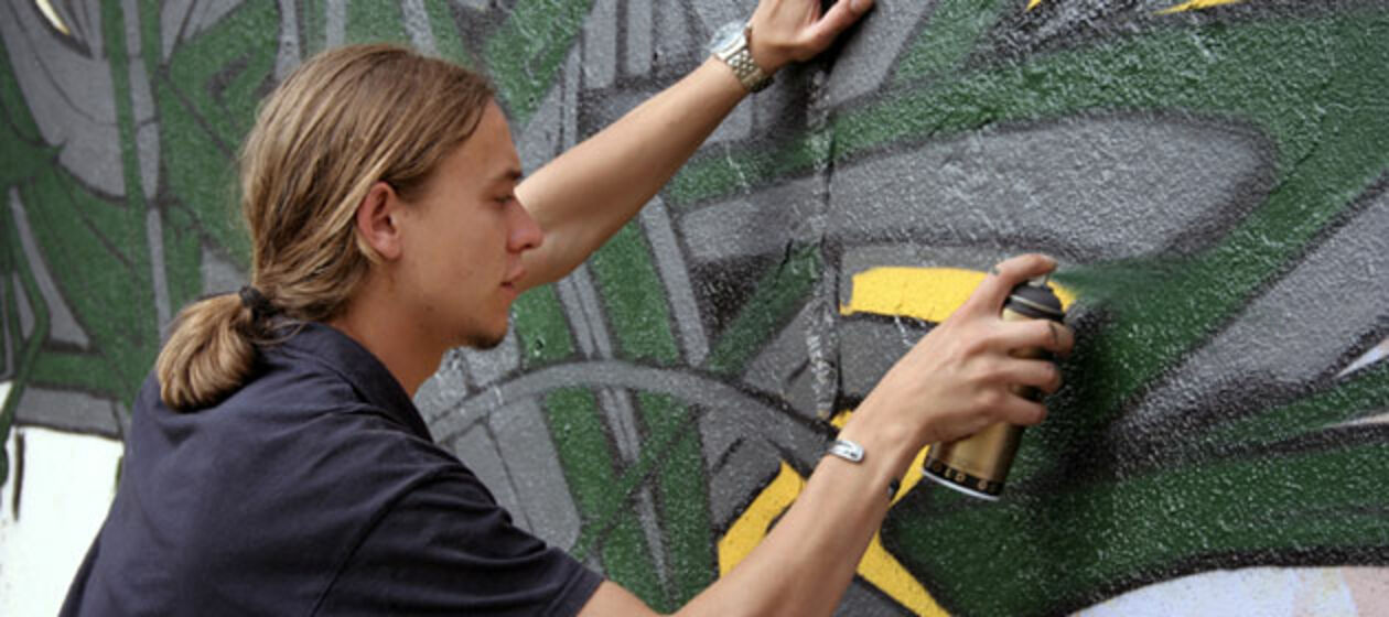 Ein Sprayer erstellt ein Graffiti