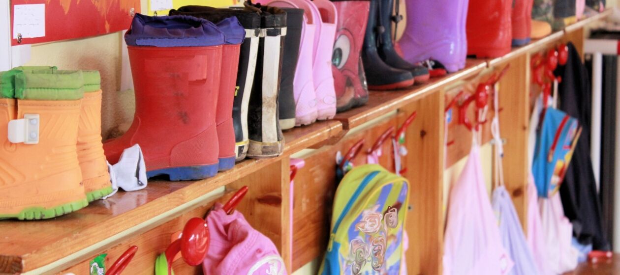 Garderobe eines Kindergartens mit Gummistiefeln und Aufhängehaken