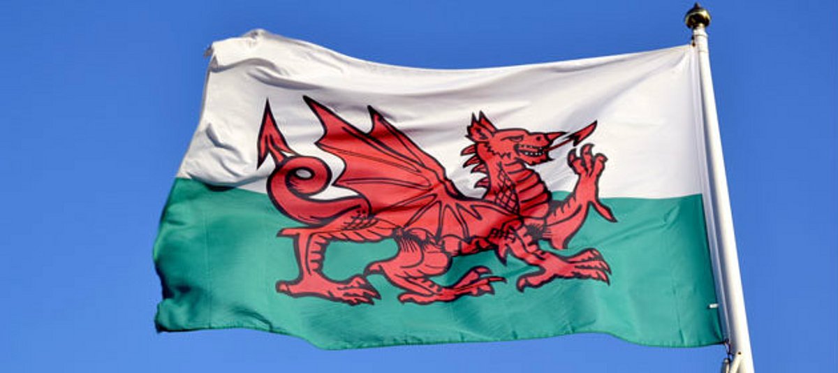 Wales-Flagge vor blauem Himmel