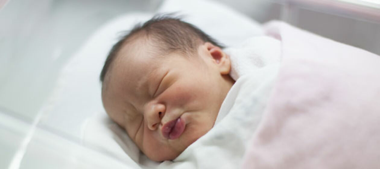 Ein Neugeborenes in seinem Bettchen
