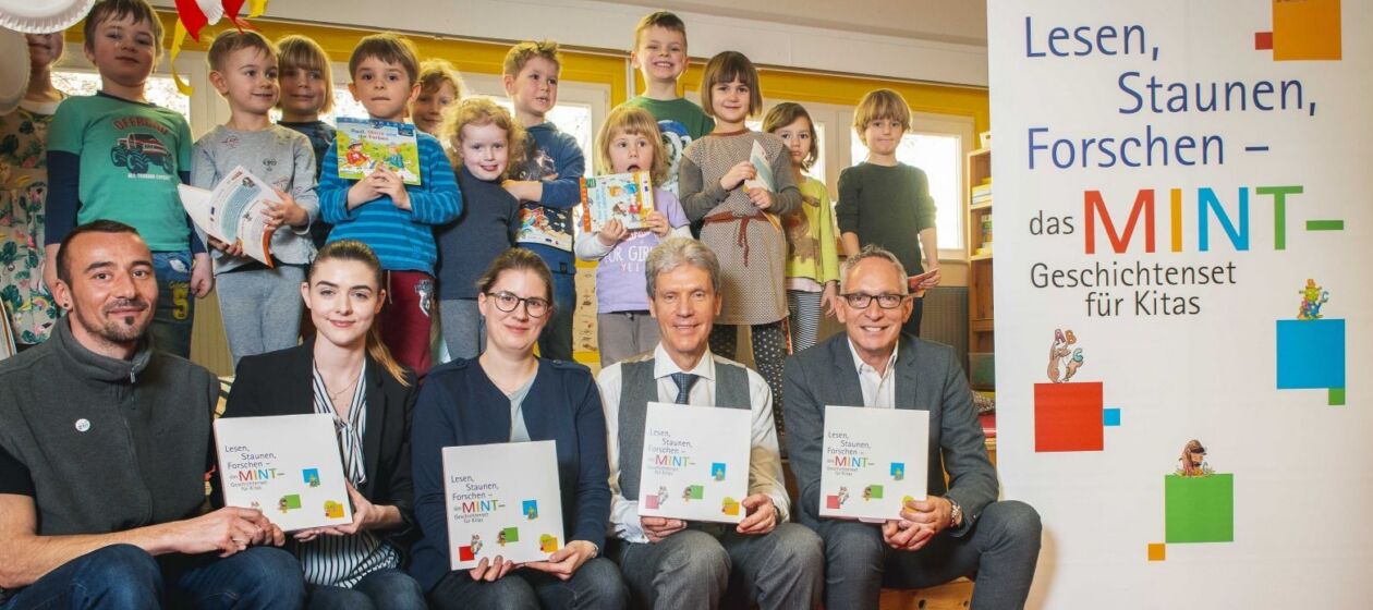 Symbolische Übergabe des ersten Exemplars an Bildungsminister Helmut Holter in Erfurt, im Hintergrund steht eine Gruppe von Kita-Kindern 