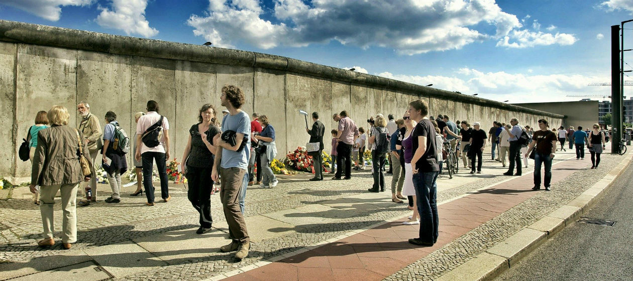 Viele Menschen stehen vor einem Teilstück der Berliner Mauer an der Bernauer Straße