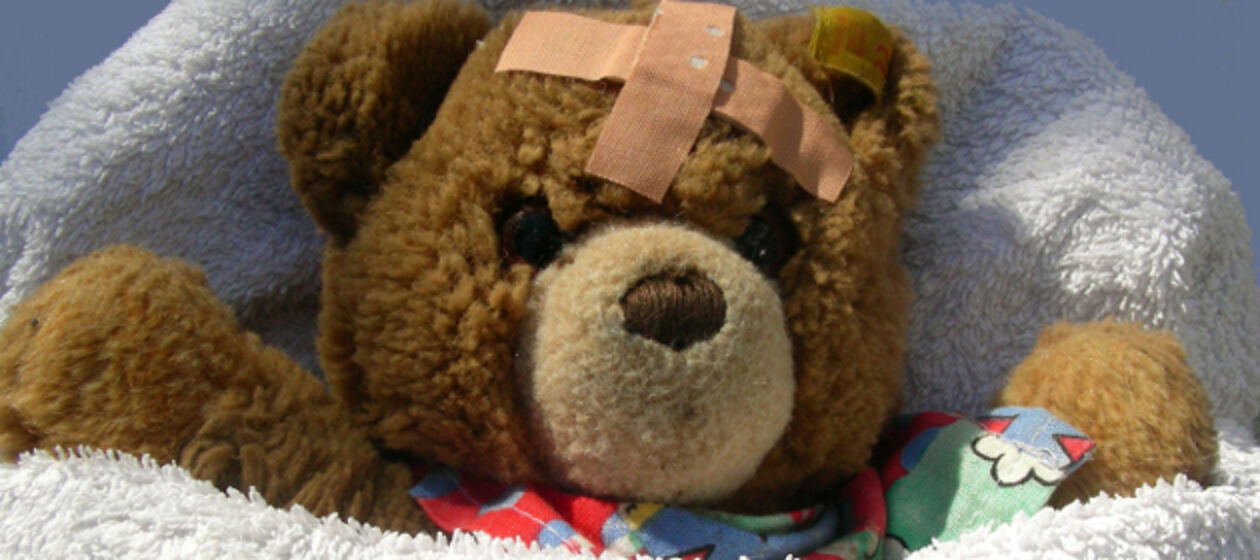 Ein Teddybär hat ein Pflaster auf der Stirn.