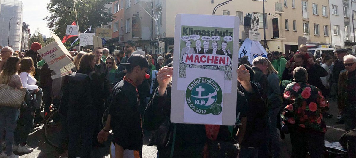 Demonstranten beim Klimastreik halten ein Banner der Katholischen Landjugendbewegung hoch