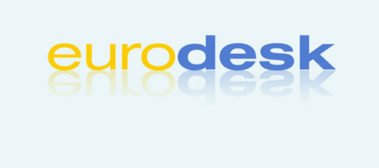 Schriftzug eurodesk mit gelben und blauen Buchstaben auf hellblauem Grund