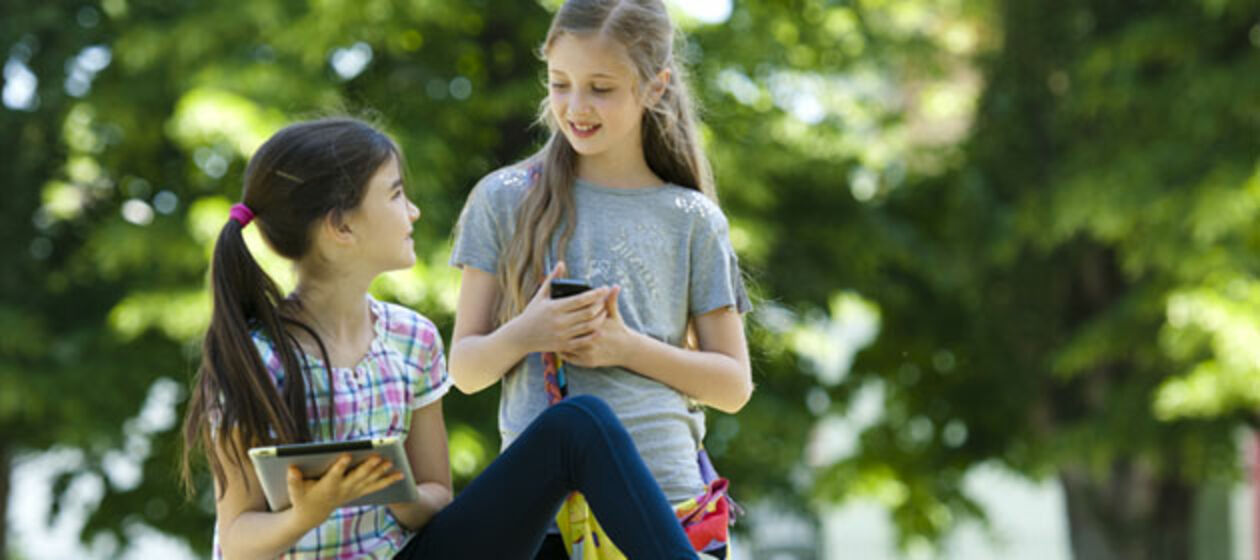 Zwei Mädchen mit Smartphone und Tablet