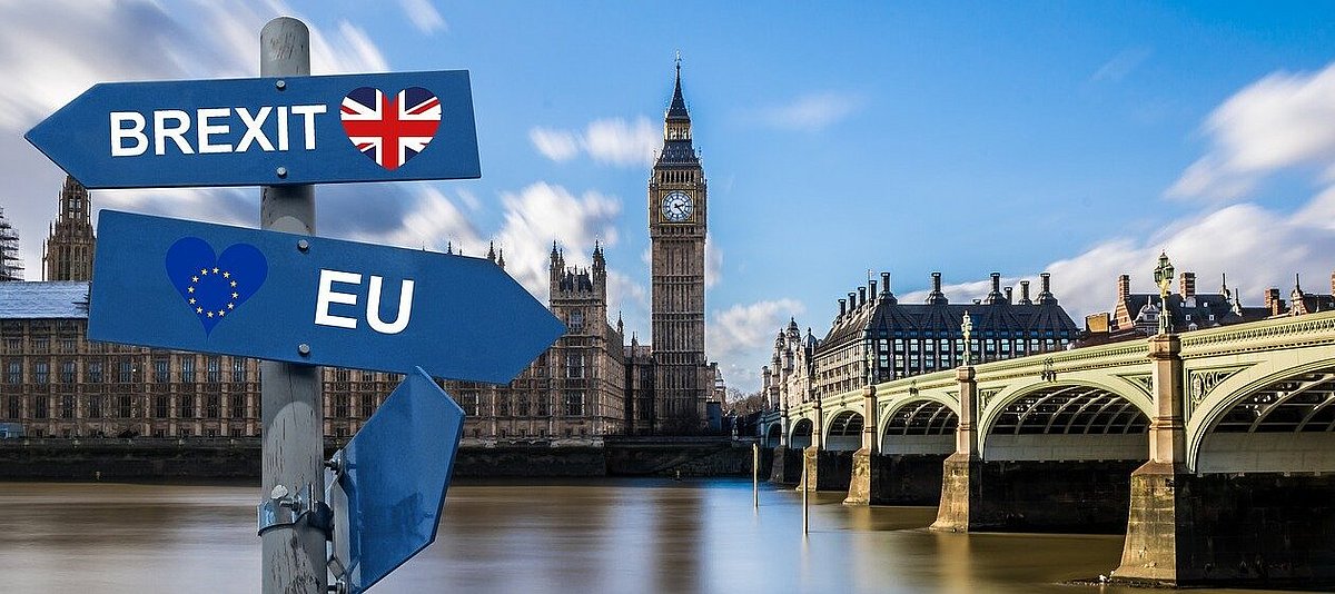 Ein Wegweiser – Brexit nach links, EU nach rechts – vor der Themse und dem britischen Parlament