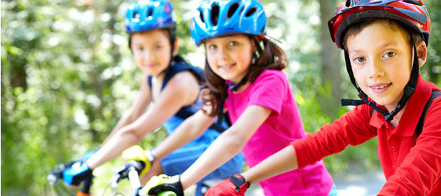 Drei Kinder mit Fahrradhelm