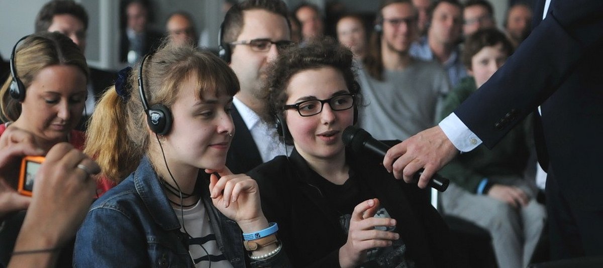 Jugendliche Teilnehmerinnen werden mit einem Mikrofon befragt