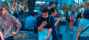 Mehrere junge Menschen schauen auf ihre Smartphones
