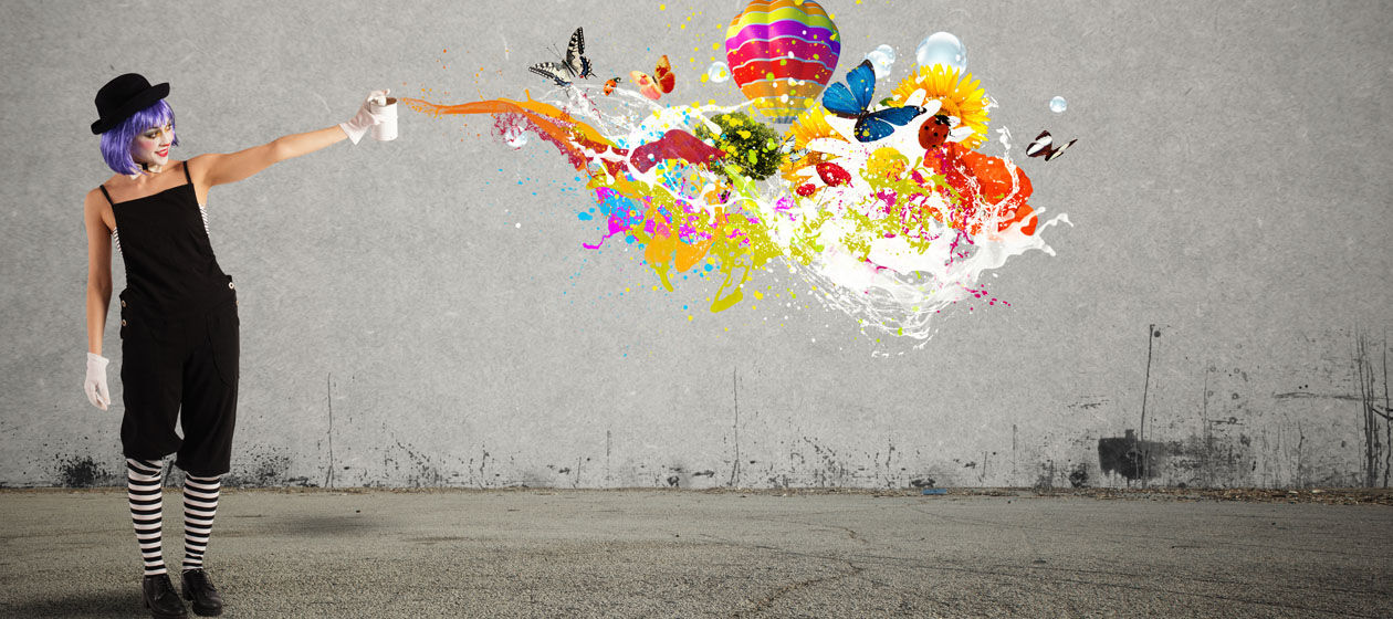 Ein weiblicher Clown imitiert das Ausschütten von Farbe auf die Wand, wobei Symbole wie Tiere und ein Heißluftballon zu sehen sind.