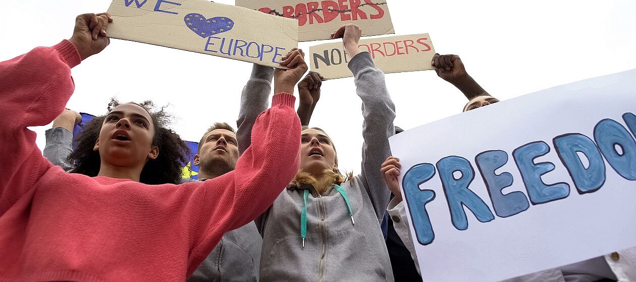 Mehrere junge Menschen halten auf einer Demonstration Schilder mit den Aufschriften 'We love Europe', 'Freedom' und 'No Borders'