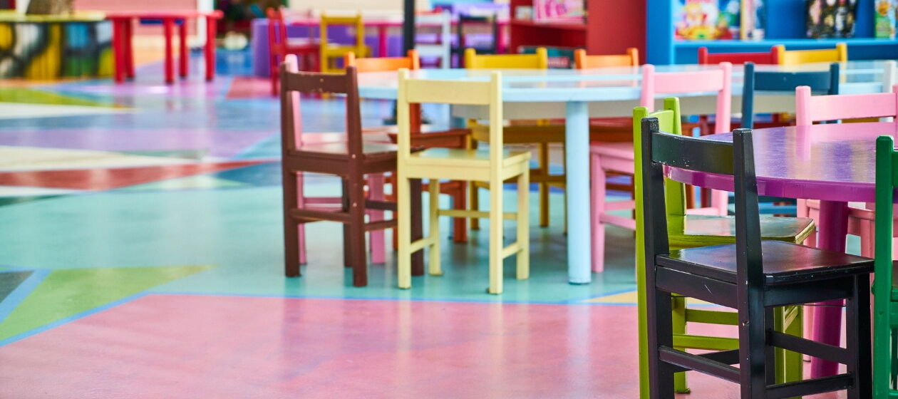 Eine Raum in einer Kindertageseinrichtung mit bunten Kinderstühlen