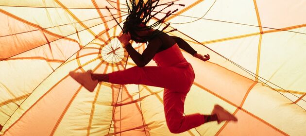Eine Jugendliche springt akrobatisch durch die Luft